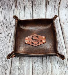 Custom quality hand crafted leather valet tray. This beautiful and functional genuine leather tray is a great addition to any home decor. Measures approximately 6"×6"  The leather patch in the center is customizable in your choice of up to three initials or one initial with name as displayed in the picture. Fastened with gorgeous copper rivets that also hold the corners of the tray.  Makes a wonderful gift that can be treasured for generations. Enjoy a stylish way to corral and organize any numb Leather Christmas Gifts, Leather Christmas, Leather Valet Tray, Leather Tray, Valet Tray, Horween Leather, Groomsmen Gift, Gift For Husband, Handcrafted Leather