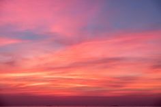 the sky is pink and blue with clouds