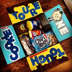 a box filled with snacks and candy on top of a wooden table