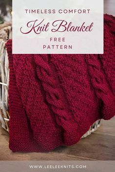 a red knitted blanket sitting on top of a wooden table next to a christmas tree