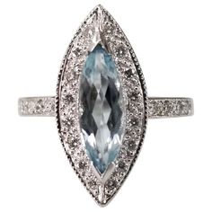 an oval cut blue topazte and diamond ring with white diamonds surrounding the band