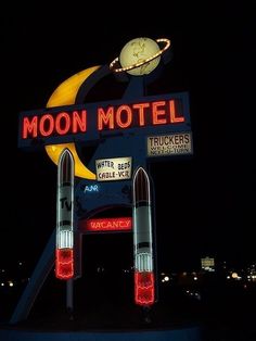 the moon motel sign is lit up at night with lights on it's sides