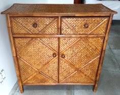 a wooden cabinet with two drawers made out of wood and wicker on the top