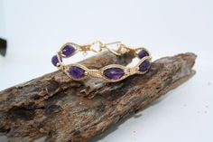 Lusciously purple Amethyst wrapped in Gorgeous 14kt Gold Filled wire with Gold filled beads on each side of the gemstones. If your a Feburary baby or just love the color purple this bracelet has it all. I also give you the option to have this bracelet made in 14kt Rose Gold fill or a Fine .935 Argentium Silver. Just choose your size and material option and I'll make this bracelet Just4u! Wire Wrapped Amethyst Bracelets In Purple, Purple Amethyst Wire Wrapped Bracelets, Purple Wire Wrapped Bangle Jewelry, Wire Wrapped Purple Amethyst Bracelets, Wire Wrapped Amethyst Bracelet, Hand Wrapped Amethyst Purple Bracelets, Purple Wire Wrapped Bracelet, Purple Wire Wrapped Bracelets As Gift, The Color Purple