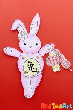 a paper cut out of a pink bunny holding a cupcake with chinese characters on it