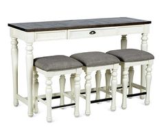 a white table with three stools underneath it