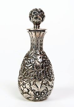 a silver vase sitting on top of a white table