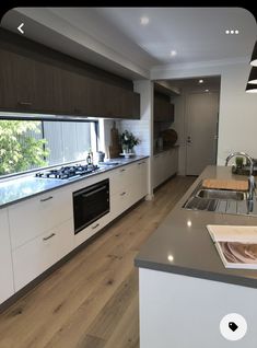 a kitchen with an oven, sink and stove top on the countertop in front of a window