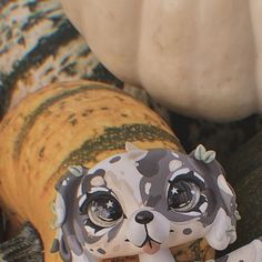 a ceramic dog figurine sitting on top of a pumpkin