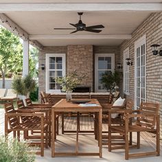 a wooden table and chairs on a patio with a ceiling fan in the middle of it