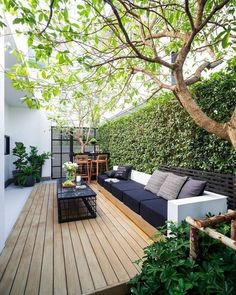 an outdoor living area with couches, tables and potted plants on the deck