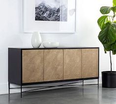 a living room with a potted plant on the sideboard