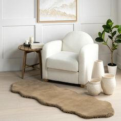 a white chair sitting in a living room next to a potted plant