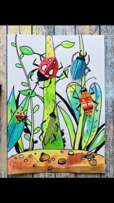 a card with ladybugs on it sitting next to some flowers and plants in the grass