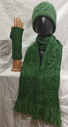 a green knitted scarf and hat on top of a mannequin's head