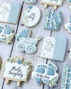 baby shower cookies decorated with blue icing and handmade ones on a wooden table