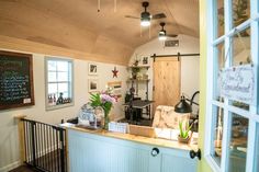 the inside of a small room with lots of furniture and flowers in vases on the counter