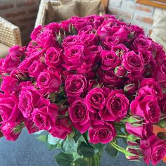 a vase filled with pink roses sitting on top of a table next to a couch