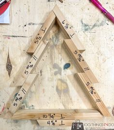 a wooden triangle that has been cut into pieces with numbers on it and measuring the height