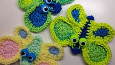 three crocheted items with googly eyes are displayed on a white table top