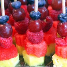 fruit skewers are arranged on top of each other