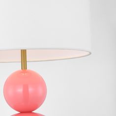 a pink table lamp with a white shade on it