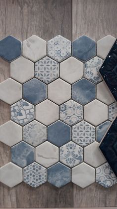 a tile floor with blue and white hexagonal tiles on it, next to a black vase