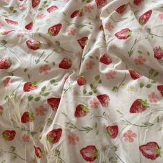 a white sheet with strawberries on it and flowers all over the bed coverlet