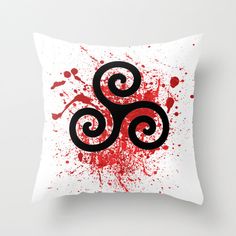 a white pillow with red paint splattered on it and an om symbol in the middle