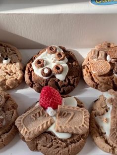 a box filled with lots of different types of cookies on top of each other and topped with marshmallows