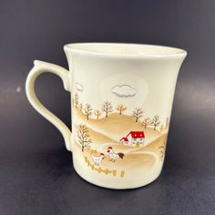 a coffee cup with a farm scene painted on it