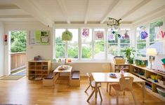 a child's playroom with wooden furniture and windows