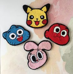 four embroidered patches with cartoon characters on them, all in different colors and sizes together