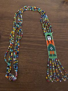 Very nice old necklace, probably Native but I can't be certain. Lovely rainbow of colored seed beads, snap closure, female beaded image with rainbow beaded fringe. 17 inches long with fringe. Artisan Multicolor Beads With Beaded Fringe, Traditional Multicolor Beaded Necklaces With Fringe, Traditional Multicolor Beaded Fringe Necklaces, Traditional Multicolor Beaded Necklace With Fringe, Artisan Multicolor Beaded Fringe, Artisan Multicolor Beaded Necklaces With Fringe, Artisan Multicolor Beaded Necklace With Fringe, Multicolor Beaded Fringe Necklaces As Gift, Multicolor Beaded Fringe Necklace Gift