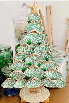 a green and white christmas tree made out of baskets on a table next to jars