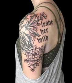 a woman's shoulder with flowers and the words, leave her wild on it