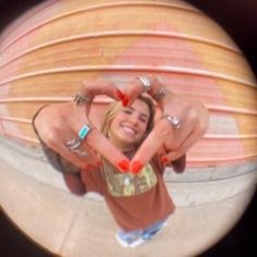 a woman making a heart shape with her hands