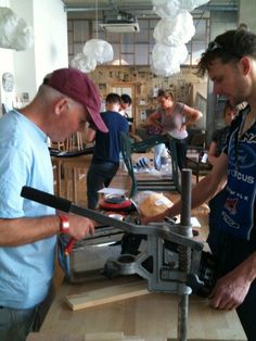 two men are working on something in a shop