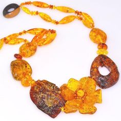 Necklace Stone(s): genuine Baltic honey amber and genuine wood Necklace Length: 19 inches Deep: 1.75 inches Weight: 66.3 grams Clasp: Toggle Stamp/Mark: N/A Origin: Poland Serial Number: n20692 Amber, an organic gemstone, is the fossilized sap of prehistoric trees which grew up to 50 million years ago. The stone has been used for jewelry since the time of Christ. The world's finest amber comes from the region around the Baltic sea. This is a DESIGNER, one-of-a-kind genuine Baltic Amber 5, hand-m Luxury Amber Gemstone Necklace, Luxury Gold Necklace With Baltic Amber, Prehistoric Trees, Amber Bead Necklace, Flower Carving, Necklace Stone, Special Flowers, 50 Million, Wood Necklace