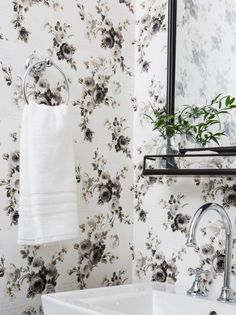 a white sink sitting under a bathroom mirror next to a wall mounted faucet