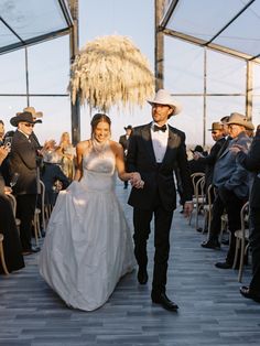 a bride and groom walking down the aisle