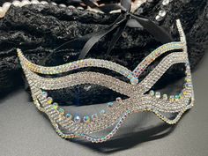 Step into the realm of mystery and elegance with our exquisite masquerade mask, adorned with high-quality crystals that glimmer and shine with every movement. Designed to capture the essence of classic masquerade allure, this mask is a masterpiece of craftsmanship, perfect for making a grand entrance at any gala, ball, or festive event. Its intricate pattern and sparkling details add a dash of glamour, transforming your presence into the highlight of the night. Whether celebrating a birthday, at Glamorous Party Headpieces With Rhinestones, Adjustable Rhinestone Headpiece For Party, Adjustable Party Headpiece With Rhinestones, Crystal Crown Headpiece For Party, Mardi Gras Party Crown Headpiece, Adjustable Crystal Headpiece For Party, Glamorous Crown Headpiece For Party, Silver Rhinestone Eye Mask For Masquerade, Silver Rhinestone Eye Masquerade Mask