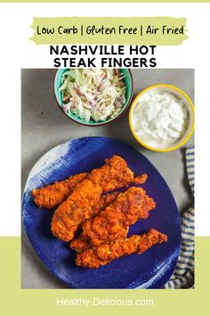 chicken wings with coleslaw and ranch dressing on a blue plate next to a bowl of sour kraut