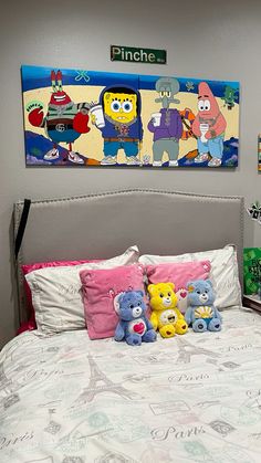 there is a bed with stuffed animals on it and two pictures above the headboard