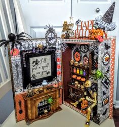 two halloween decorations are sitting on a table next to a door with the words happy halloween written in it