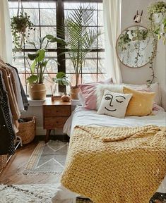 a bedroom with lots of plants on the windowsill and a bed in front of it