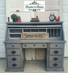 an old desk with drawers and a sign on it that says farmers market in front of a garage door