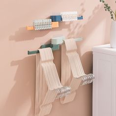 there are two toothbrushes hanging on the wall next to a vase with flowers