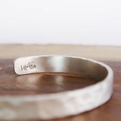 Hammered Silver Cuff 1/4" This Hammered Silver Cuff shines with the allure of a sunlit peak. Its versatility makes it perfect for everyday wear, enhancing any ensemble with a touch of understated sophistication.It's more than just adornment; it's a canvas for your personal story. With the option to personalize it, you can engrave a secret message, a cherished mantra, or a reminder of your own strength – keeping it close to your wrist as a source of inspiration. Let the Hammered Silver Cuff Brace Hand Stamped Jewelry, Stamped Jewelry, Hammered Silver, Silver Cuff Bracelet, Black Tourmaline, Silver Cuff, Free Jewelry, Mantra, Cuff Bracelet