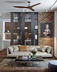 a living room filled with furniture and a brick wall